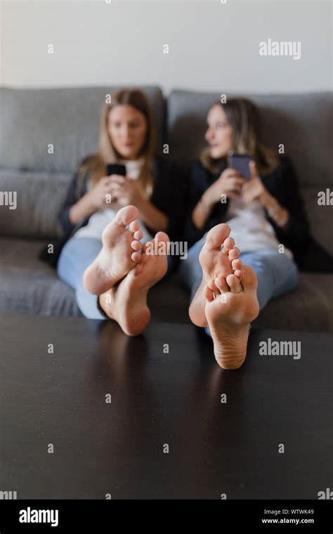 Girls In A Couch With Feet On A Table Stock Photo Alamy