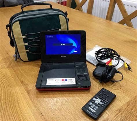 Red Sony Portable Dvd Player With Remote Control And Bag In