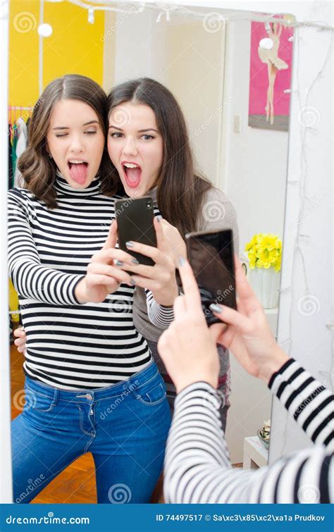 Two Beautiful Teenage Girls Taking Selfies While Making Faces Stock