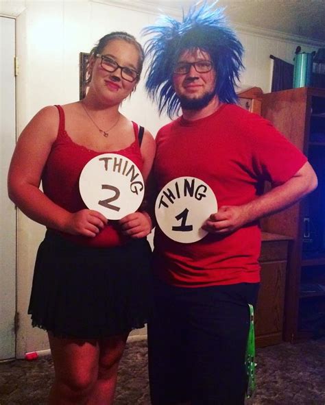 Two People Dressed In Costumes Standing Next To Each Other Holding Signs That Say Thing 1 Thing