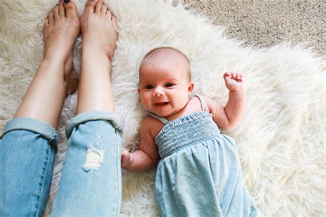 Happy Baby Laying Beside Mom On The Floor By Stocksy Contributor