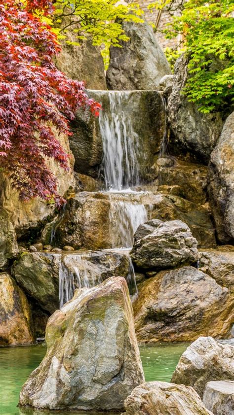 Waterfall Pouring On Pond Between Colorful Autumn Trees During Daytime