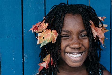 smiling black girl with fall leaves in her hair by stocksy contributor gabi bucataru stocksy