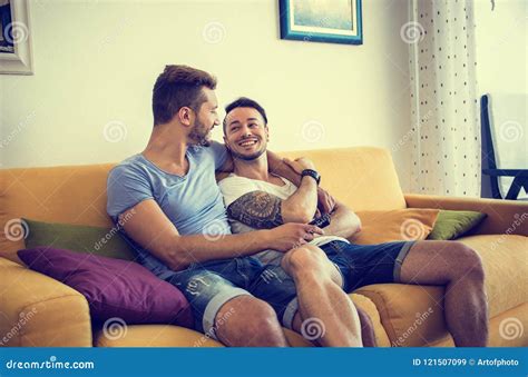 Two Gay Men On Sofa Embracing At Home Stock Image Image Of Care