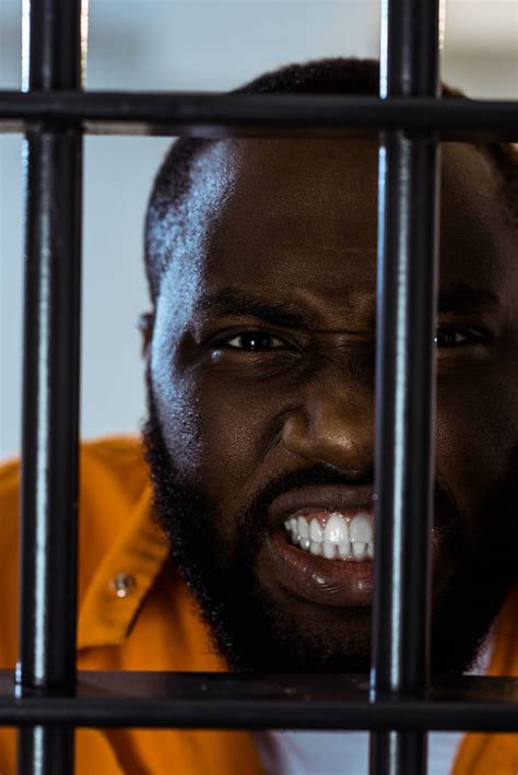 Aggressive African American Prisoner Behind Prison Bars Free Stock