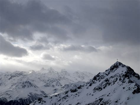 Cross On Top Of Snowy Mountain Under Dark Cloudy Sky Free