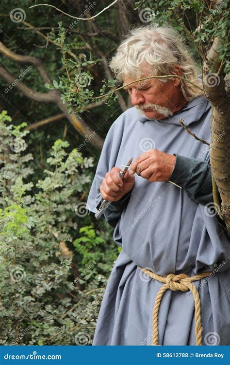 Medieval Peasant Whittling A Piece Of Wood Editorial Stock Photo