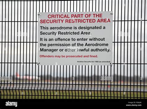 Security Restricted Area Sign On The Fence Between The Runway Visitor