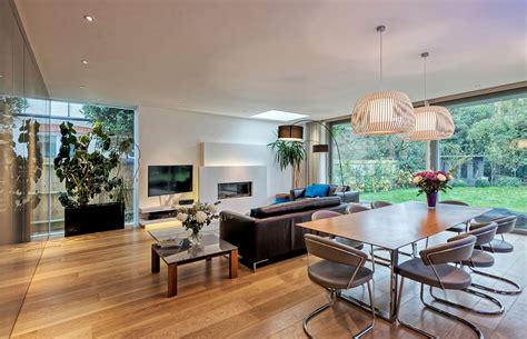 A Modern Living Room And Dining Area With Wood Floors Large Windows