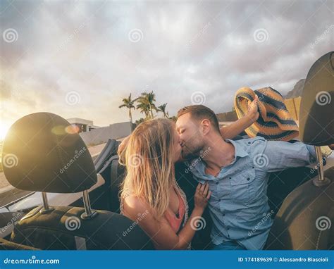 Happy Young Couple Having Kissing In Convertible Car During Their Road