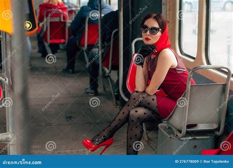 A Stylish Woman In Sunglasses In A Red Dress Tights Red Shoes And A