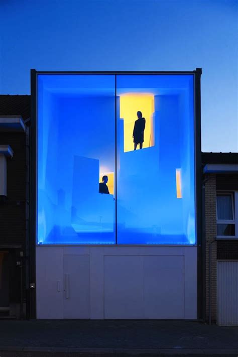 Two People Standing In Front Of A Building With Blue Lights On The