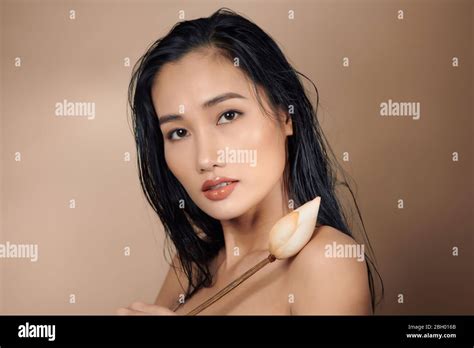 Portrait Of A Beautiful Asian Women Tanned Skin With Long Hair Holding Dried Lotus Buds And