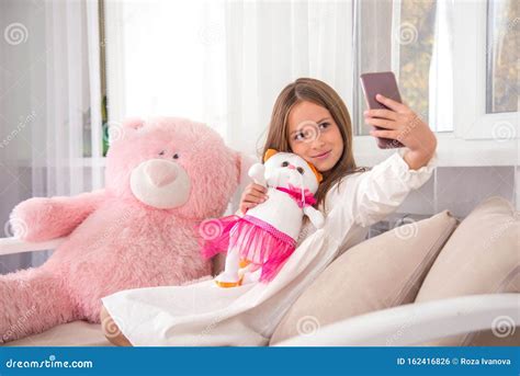 Attractive Girl Has Fun At Home With Her Favorite Soft Toys She Taks A Selfie On The Phone With