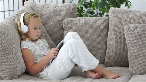 Girl Lying On Couch With Tablet Pc And Listening To Music Stock Video