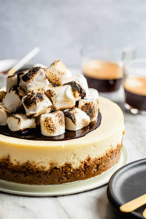 S Mores Cheesecake Topped With Toasted Marshmallows In Front Of Cups Of Espresso Baking