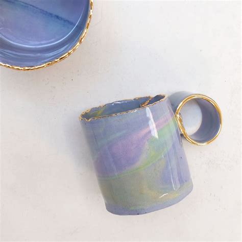 Two Blue Cups Sitting Next To Each Other On A White Counter Top With
