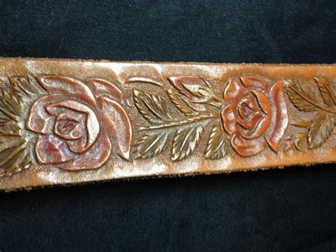 Adding conchos attaching a buckle leather belt lined reptile print belt. Hand carved and tooled western belt with rose pattern style