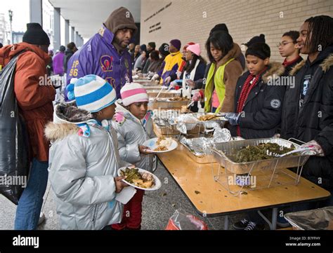 Volunteers Serve Meal To The Homeless At Outdoor Soup Kitchen Stock