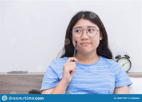 Asian Girl Teen Nerd Glasses Thinking Homework At Home Indoor Stock