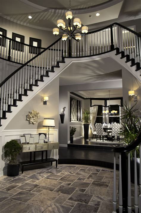 Double Arched Stairs Descending Down The Round Foyer Creating A Two Story Entrance Way Floor Is