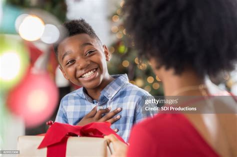 African American Mom Gives Her Young Son A Christmas T High Res