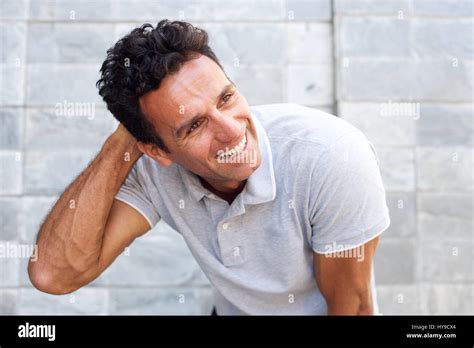 Close Up Portrait Of A Handsome Older Man Laughing With Hand In Hair