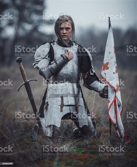Girl In Image Of Jeanne Darc In Armor Kneels With Flag In Her Hands And