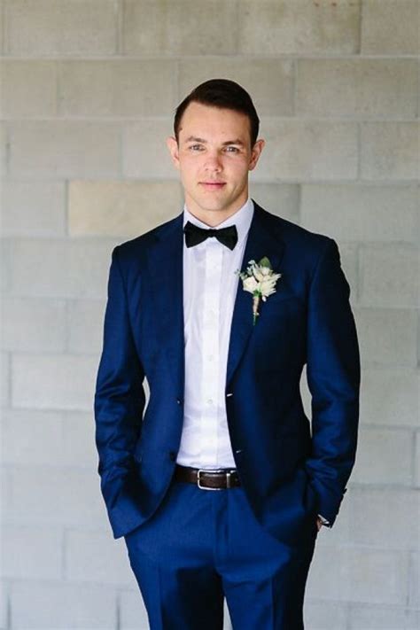 handsome groom in blue suit with bow tie photo credit ben howland photography benhowland