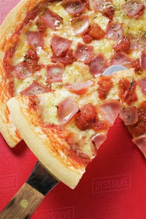 Ham Cheese And Tomato Pizza With Slice On Server Stock Photo Dissolve