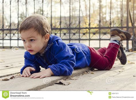 Child Laying On Ground Outside Stock Image 42911071
