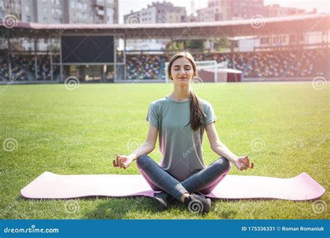 Woman Training Outdoors She S Sitting On Mat On Green Grass And Doing
