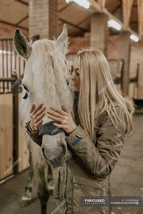 Long Haired Woman Embracing Dapple Grey Horse With White Mane Muzzle In