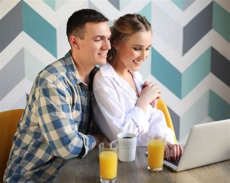 Loving Couple Having Breakfast And Looking At Laptop Compute Stock