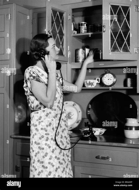 1930er Jahren Frau Hausfrau TrÄgt SchÜrze KÜche Reden Am Telefon Setzen
