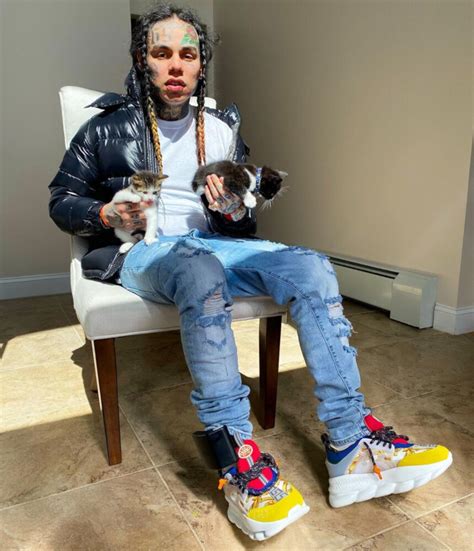 6ix9ine holds kittens in a moncler puffer and versace sneakers inc style