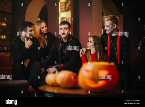 Young People In Costumes Are Celebrating Halloween In Cafe Stock Photo