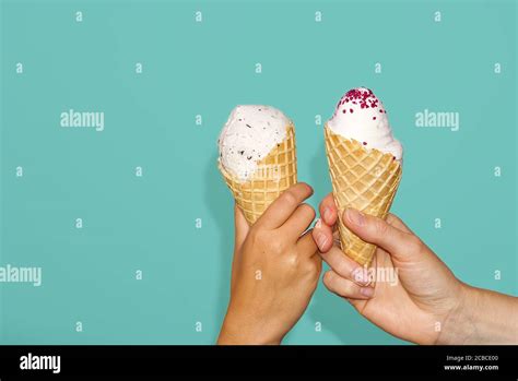 Mother And Daughter Hands Holds Ice Cream Corn With Milk Ice Cream Isolated On A Turquoise