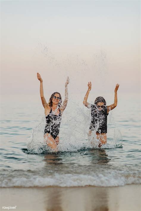 Download Premium Image Of Cheerful Girls Splashing Water At The Beach