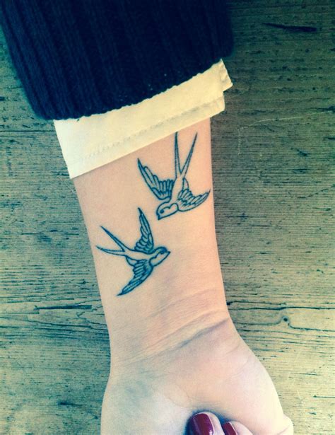 A Woman S Wrist Tattoo With Three Birds On The Left Side Of Her Arm