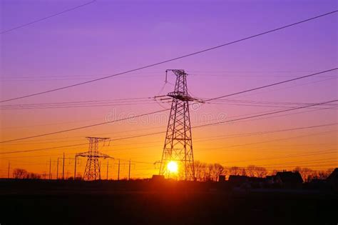 High Voltage Distribution Power Lines Pylon At Sunset Stock Photo