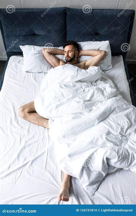 Handsome Shirtless Bearded Man Sleeping In Bed Under White Blanket