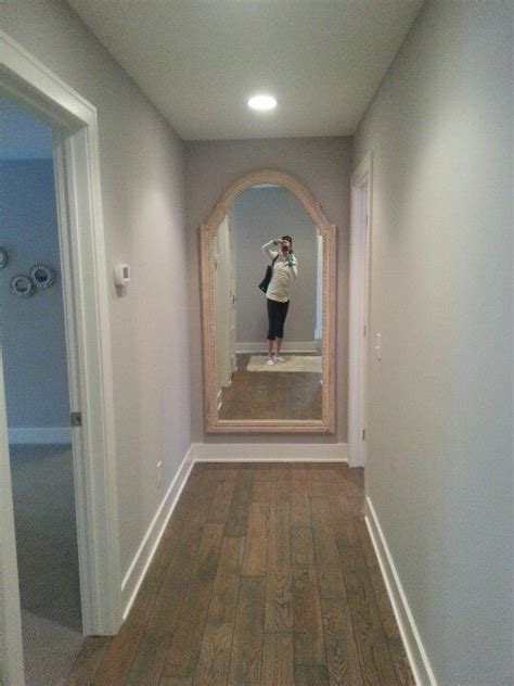 a woman taking a selfie in front of a mirror on the wall next to a door