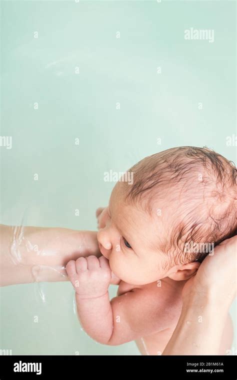 Madre Bañándose Bebé Recién Nacido Sosteniendo La Cabeza Y El Cuello