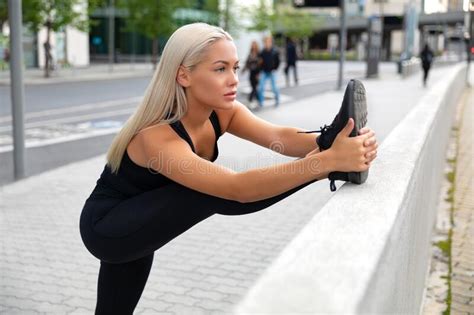Gorgeous And Flexible Blonde Woman Stretching In Modern City Stock