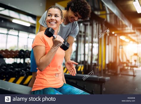 Young Beautiful Woman Doing Exercises With Personal Trainer Stock Photo