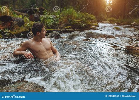 Guy Enjoying The Beauty Of Nature While Standing In The River Stock