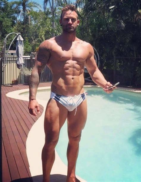 A Man Standing In Front Of A Swimming Pool With His Shirt Off And No
