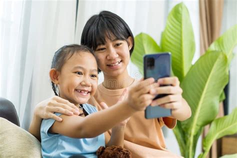 Happy Asian Girl With Sister Play On The Smart Phone Together Stock Image Image Of Browsing