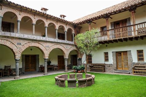 The Courtyard Of An Old Spanish Style House With Stone And Brick Arches